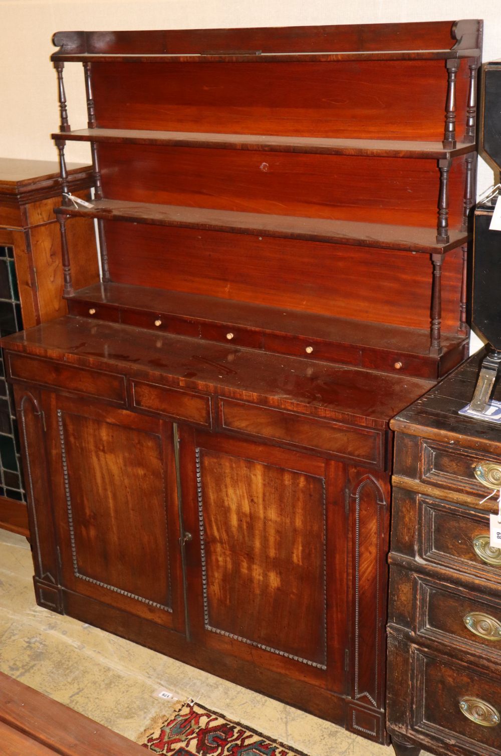 A late regency chiffonier sideboard with open rack over